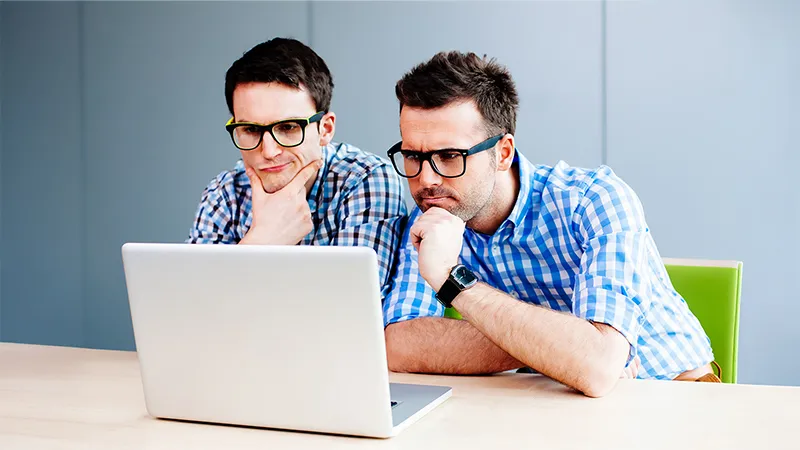 Two website consultants looking at a laptop